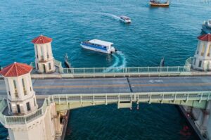 Aerial view of a tour boat beside the Bridge of Lions