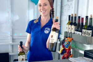 Crew member presenting a wine bottle at the onboard bar