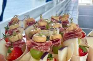 Small servings of meats, cheese and fruit displayed for guests